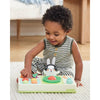 Child playing with a musical toy on a bed